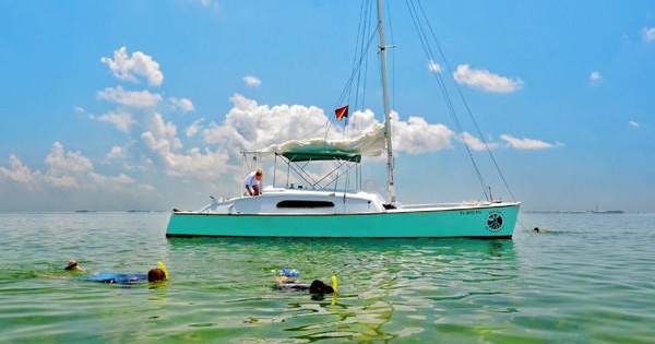The Java Catamaran anchored in the pristine shallow waters off of Key West, while passengers snorkel.